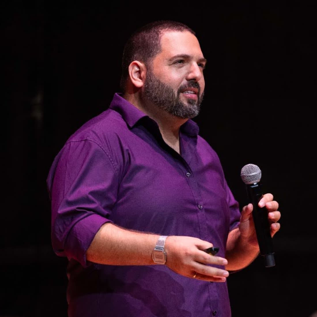 Ben Rotenberg lecturing on stage with a microphone