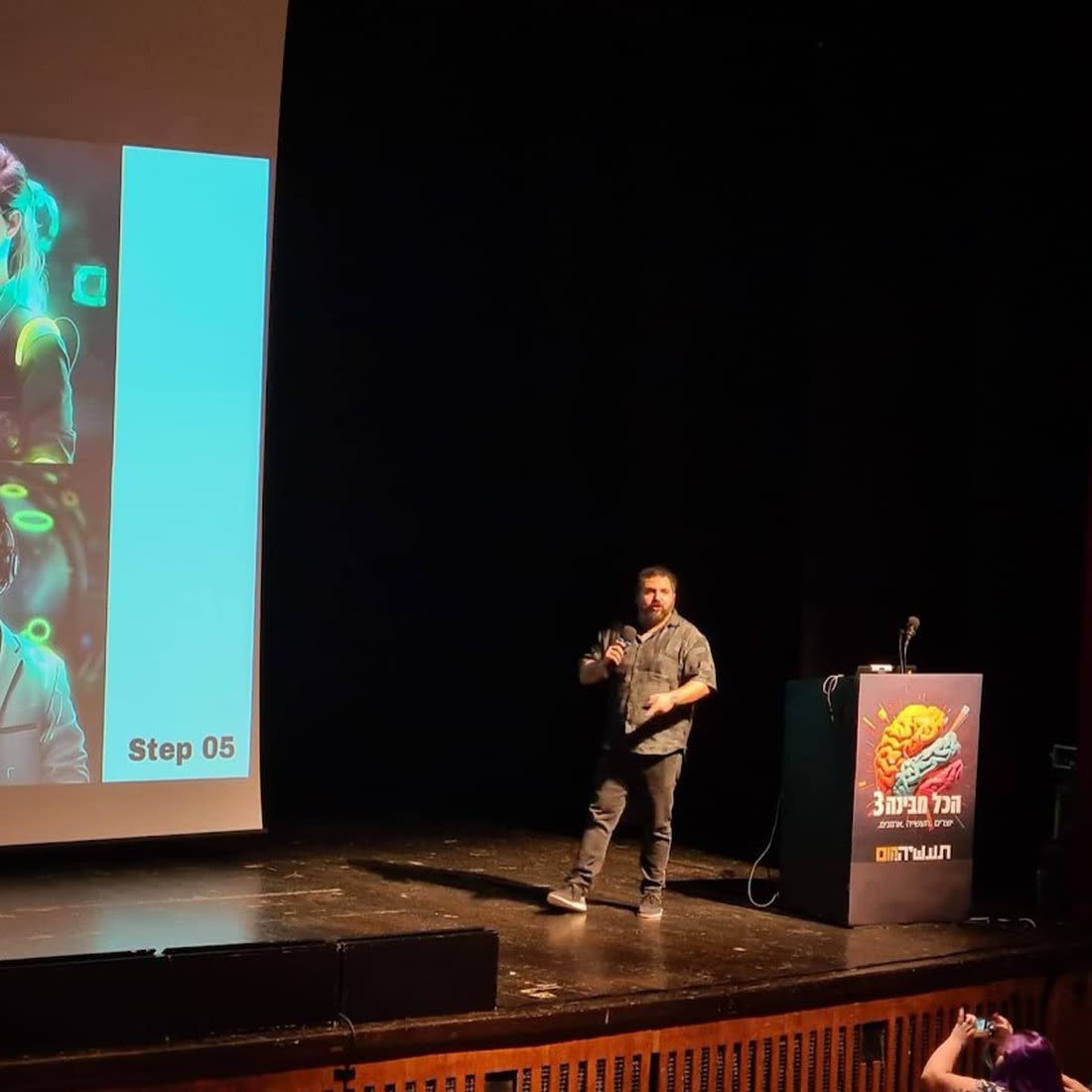 Ben Rotenberg on stage in front of an audience and a large screen