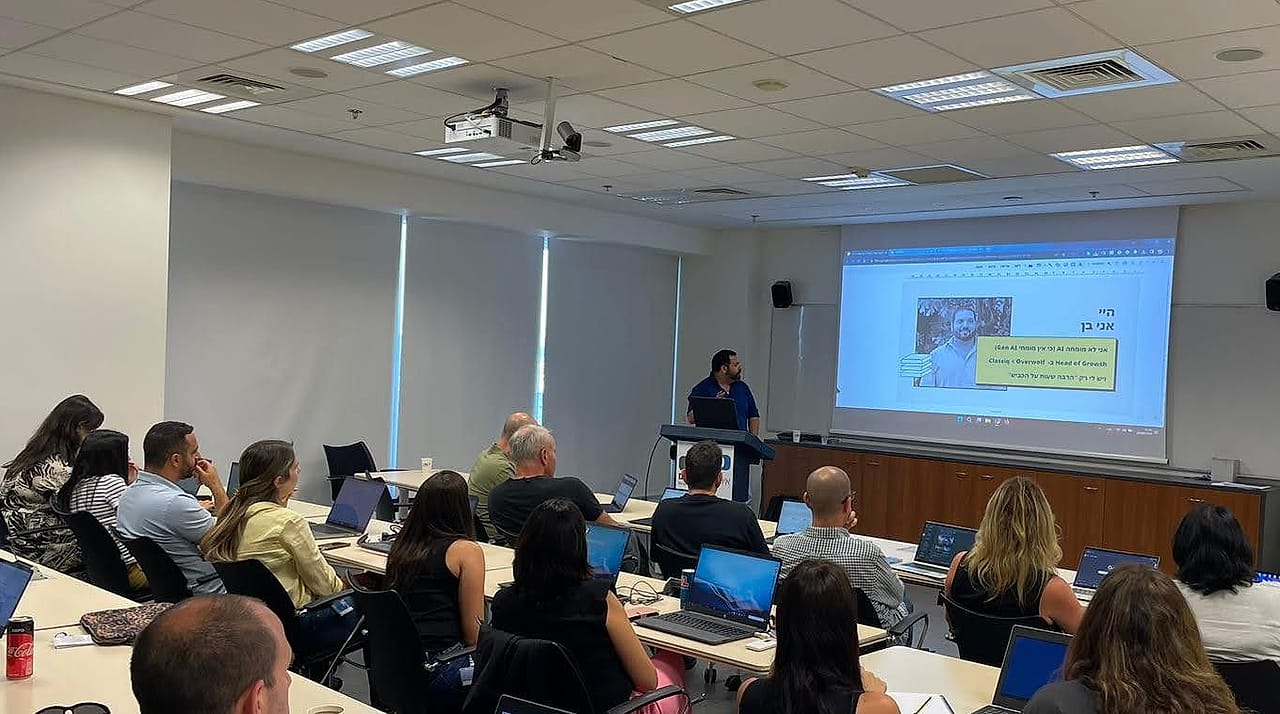 Ben Rotenberg delivering AI training in a corporate classroom full of participants with laptops